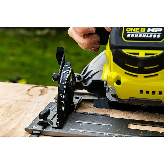 Ryobi ONE+HP Akku-Handkreissäge RC S18X1-0 - Ohne Akku, Durchmesser Sägeblatt: 184 mm, 4.500 U/min - Nahaufnahme einer Ryobi ONE+ HP Brushless Kreissäge, die auf einem Holzbrett steht, wobei der Fokus auf dem Winkelmesser liegt.