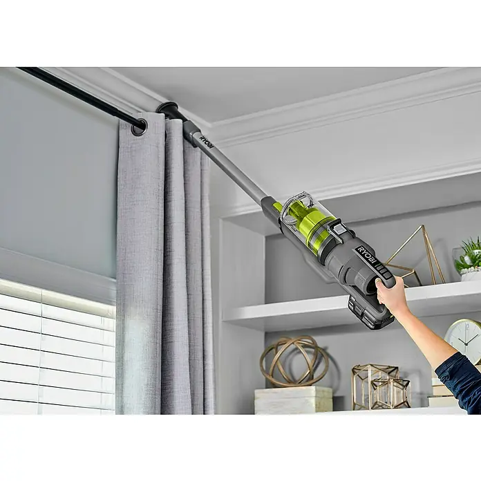 Ryobi ONE+ Akku-Handstaubsauger RSVS18-0 - 18 V, Ohne Akku - Kabelloser RYOBI-Staubsauger, der von einer Person zum Reinigen einer Gardinenstange verwendet wird. Das Haus ist sauber und ordentlich.