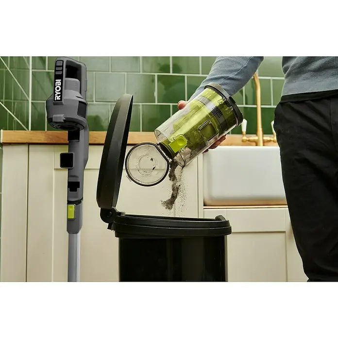 Ryobi ONE+ Akku-Handstaubsauger RSVS18-0 - 18 V, Ohne Akku - Ein Mann leert einen RYOBI-Akku-Staubsaugerbehälter in einen Mülleimer, wobei der Staubsauger im Hintergrund steht.