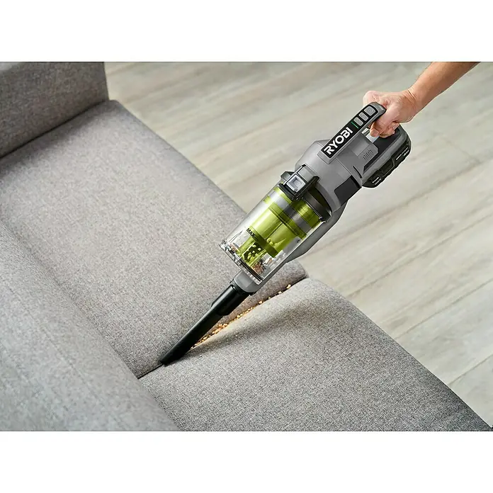 Ryobi ONE+ Akku-Handstaubsauger RSVS18-0 - 18 V, Ohne Akku - Nahaufnahme eines Ryobi Akku-Staubsaugers, der zum Reinigen einer grauen Couch verwendet wird.