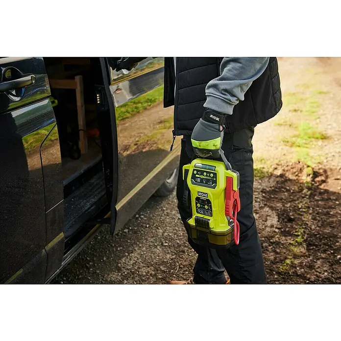 Ryobi ONE+ Starthilfegerät RJSC18-0 - Ohne Akku, Ladestrom: 30 A - Nahaufnahme eines Ryobi-Batterieladegeräts in Gelb und Schwarz, das von einer Person in Arbeitskleidung gehalten wird.