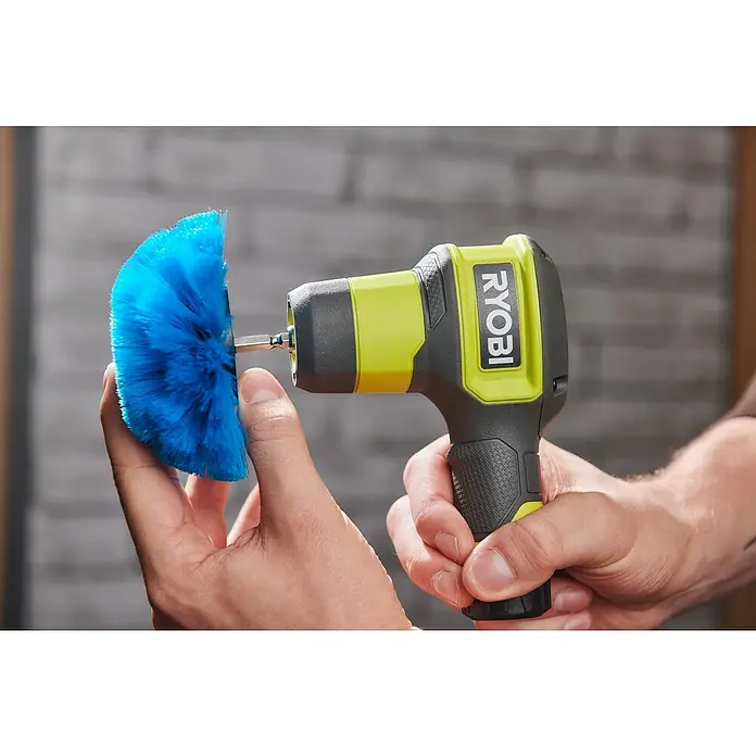 Ryobi Ersatzbürstenkopf RACLRS110 - Weich, Passend für: Ryobi Akku-Reinigungsbürste RSCR4 - Nahaufnahme eines Ryobi Akku-Reinigungsbürste mit blauem Bürstenkopf, gehalten in Händen vor unscharfem Hintergrund.