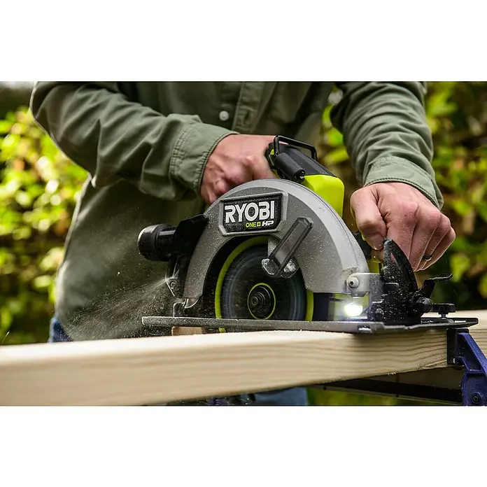 Ryobi ONE+HP Akku-Handkreissäge RC S18X1-0 - Ohne Akku, Durchmesser Sägeblatt: 184 mm, 4.500 U/min - Eine Ryobi ONE+ HP Kreissäge in Aktion, die ein Holzbrett durchschneidet, mit Spänen, die im Flug zu sehen sind. Präzision und Kraft vereint!