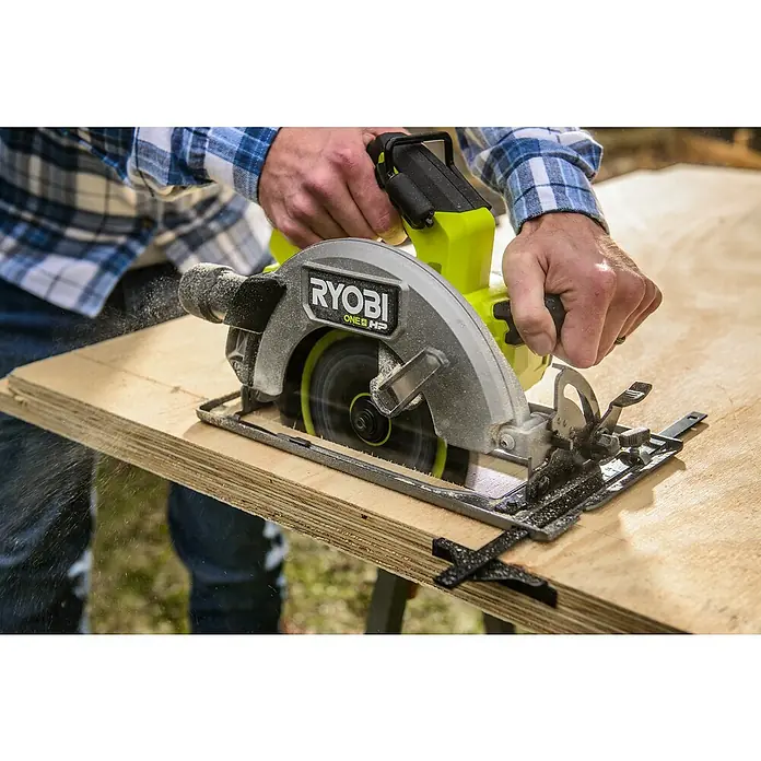 Ryobi ONE+HP Akku-Handkreissäge RC S18X1-0 - Ohne Akku, Durchmesser Sägeblatt: 184 mm, 4.500 U/min - Ein Handwerker benutzt eine Ryobi Kreissäge, um Holz zu schneiden, wobei Sägespäne in der Luft sind. Das Elektrowerkzeug ist für präzise Schnitte konzipiert.