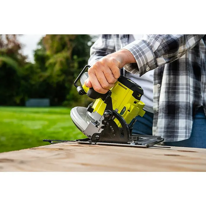 Ryobi ONE+HP Akku-Handkreissäge RC S18X1-0 - Ohne Akku, Durchmesser Sägeblatt: 184 mm, 4.500 U/min - Nahaufnahme einer Person, die eine gelbe Ryobi Kreissäge auf einem Holztisch verwendet, um einen präzisen Schnitt auszuführen.