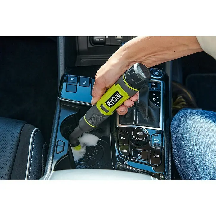 Ryobi 4V USB Akku-Reinigungsbürste RDS4-0 - 4 V, Ohne Akku - Nahaufnahme einer Person, die mit einem Ryobi-Elektrowerkzeug die Getränkehalterung in einem Auto reinigt.