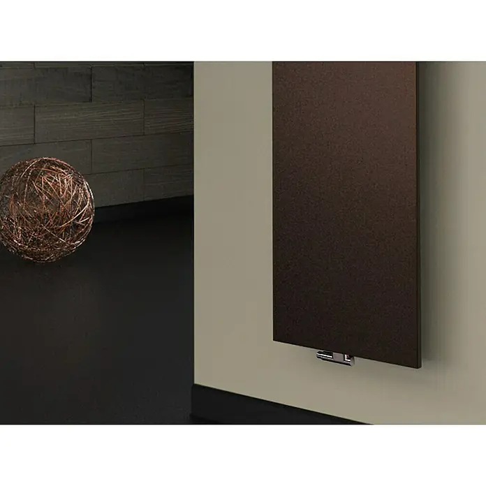 Szagato Designheizkörper Manhattan 3 - B x H: 470 x 1.800 mm, Wärmeleistung bei Vorlauftemperatur von 75 °C (D: 50): 1.118 W, Braun, Mit 1 Handtuchhalter (50 mm) - Ein moderner, brauner Heizkörper hängt an einer hellen Wand, ergänzt durch ein dekoratives Geflecht aus Zweigen.