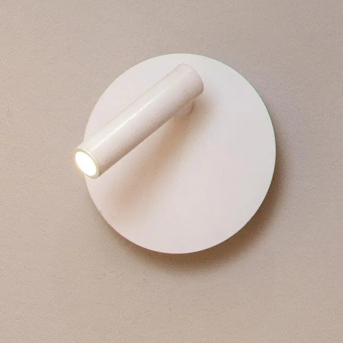 Lucide Akku-Wandleuchte Jolijn - 12 x 12 x 9 cm, Weiß, Neutralweiß, 2 W, IP20 - Nahaufnahme einer runden, rosafarbenen Wandleuchte mit einem zylindrischen, verstellbaren Strahler, der ein warmes Licht ausstrahlt.