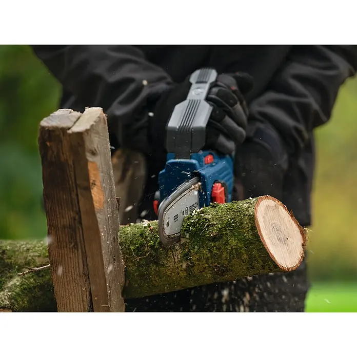 Bosch Professional AMPShare 18V Akku-Astsäge GKE 18V-15 - 18 V, Ohne Akku, Schwertlänge: 15 cm - Nahaufnahme einer Person, die ein Stück Holz mit einer blauen Bosch-Akku-Kettensäge sägt.