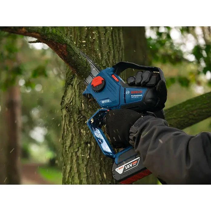 Bosch Professional AMPShare 18V Akku-Astsäge GKE 18V-15 - 18 V, Ohne Akku, Schwertlänge: 15 cm - Eine Bosch Akku-Kettensäge GKE 18V-15 beim Beschneiden eines Astes, mit Handschuhen und guter Sicht auf Akku und Sägeblatt.
