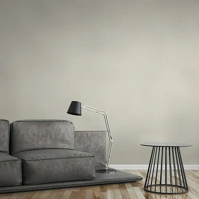 A.S. Création Greenery Vliestapete Borneo - Creme, Uni, 10,05 x 0,53 m - Graues Sofa mit Stehlampe und Beistelltisch. Minimalistisches Design für ein modernes Wohnzimmer mit stilvoller Möblierung.