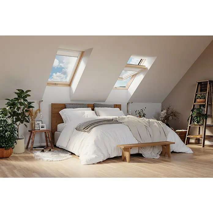 Solid Elements Dachfenster Thermo78 x 140 cm - Gemütliches Schlafzimmer mit Dachfenstern, die Tageslicht hereinlassen. Das Bett ist mit weißer Bettwäsche und einer grauen Decke versehen.