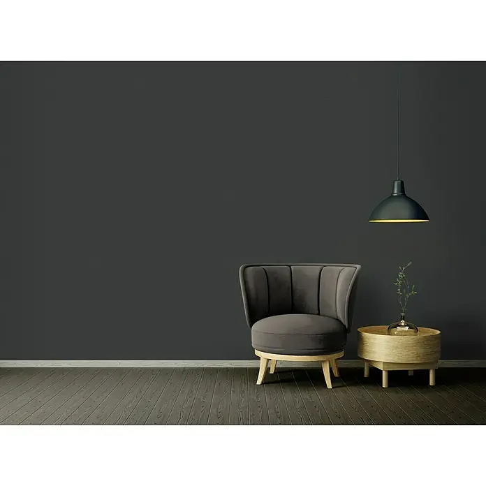 A.S. Création Ethnic Origin Vliestapete - Schwarz, Uni, 10,05 x 0,53 m - Ein modernes Wohnzimmer mit einem grauen Sessel, einem Beistelltisch aus Holz und einer schwarzen Hängelampe. Der Fokus liegt auf dem stilvollen Sessel.