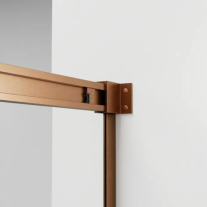 GME Mampara de ducha frontal Basic - L x An x Al: 75 x 72 x 196 cm, Vidrio serigrafiado, Cobre - Primer plano de un elegante sistema de herrajes para puertas correderas de bronce montado en una pared blanca. El acabado realza el diseño.