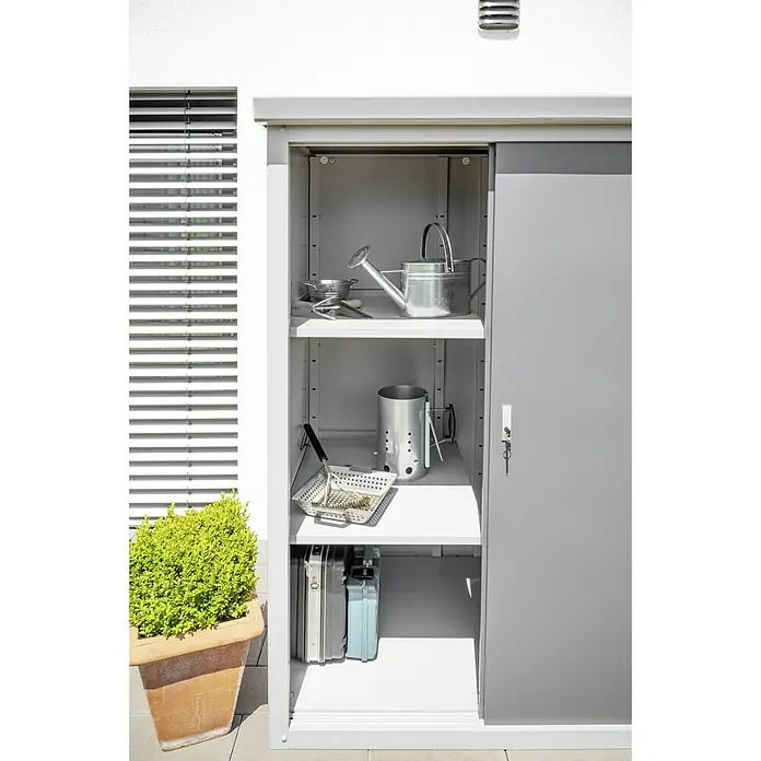 Trimetals Geräteschrank Guardian D63 - Außenbreite inkl. Dachüberstand: 176 cm, Außentiefe inkl. Dachüberstand: 89 cm, Stahl, Lichtgrau - Ein grauer Gartenschrank mit Gartengeräten auf den Regalen, darunter Gießkannen, Werkzeug und Koffer.