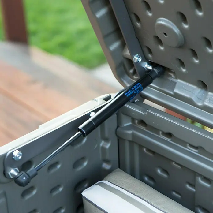 Lifetime Gartenbox Harmony - 128 x 64 x 67 cm, Lichtgrau, Kunststoff - Nahaufnahme des Deckelmechanismus einer Suncast Aufbewahrungsbox, der die Gasdruckfeder zeigt, die ein sanftes Öffnen und Schließen ermöglicht.
