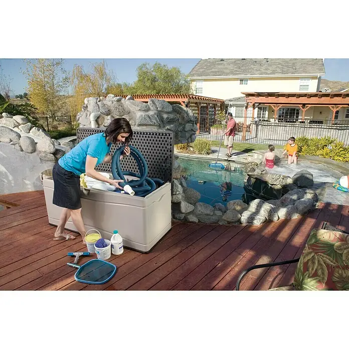 Lifetime Gartenbox XXL - L x B x H: 153 x 61 x 66 cm, Kunststoff - Eine Frau räumt Poolzubehör in einer Suncast Aufbewahrungsbox im Freien. Praktisch und geräumig für Poolutensilien!