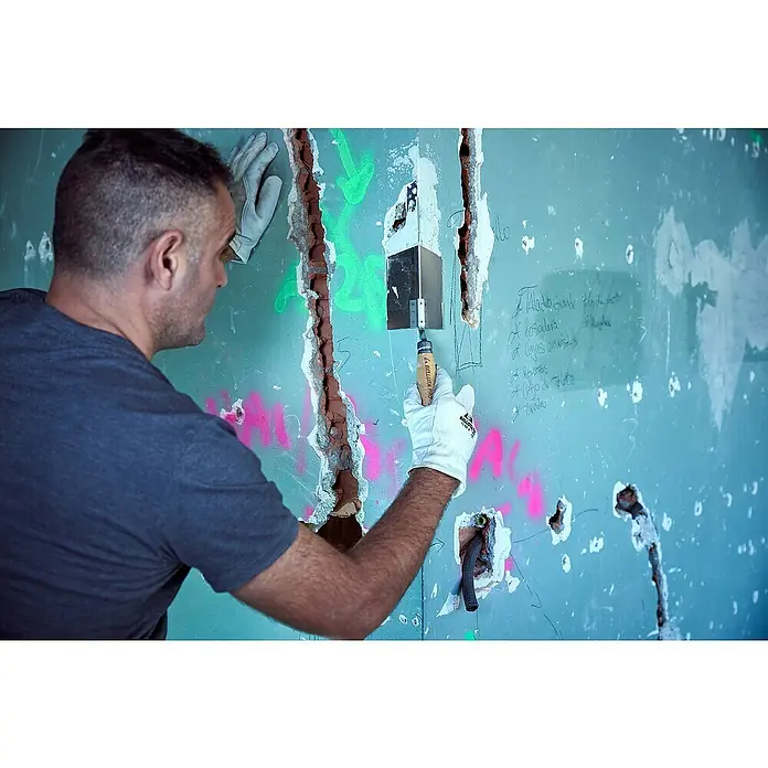 Bellota Espátula para ángulos exteriores - Angular - Un hombre está reparando una pared con una espátula. La herramienta es una ayuda esencial para la construcción y la reparación.