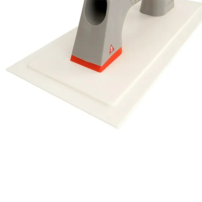 Bellota Llana de alisado de Polipropileno flexible 5869 - 140 x 80 mm - Primer plano de una llana con mango gris y base roja sobre una superficie blanca.