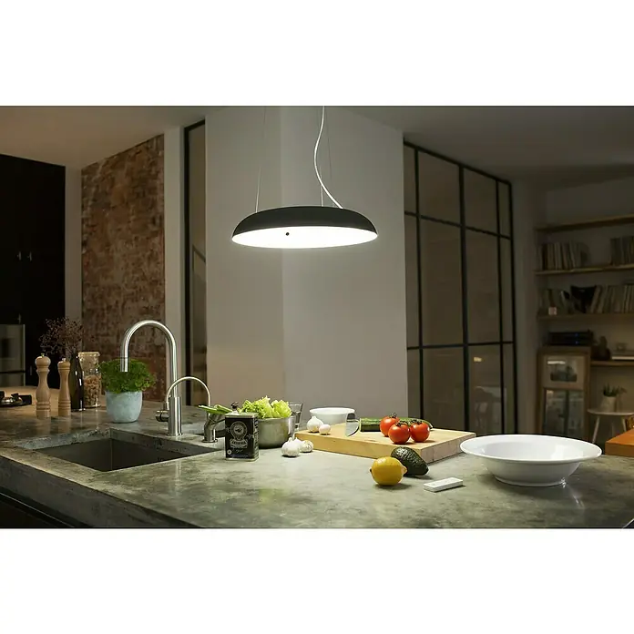 Philips Hue LED-Pendelleuchte rund White Ambience Amaze - 25 W, Ø x H: 43,4 x 150 cm, Schwarz - Küchenszene mit moderner Hängelampe über einer Arbeitsfläche mit frischen Zutaten.