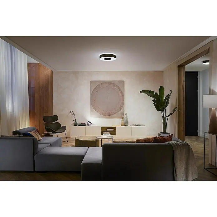 Philips Hue LED-Deckenleuchte rund White and color ambience Infuse M - Ø x H: 38,1 x 8,4 cm, RGBW - Ein modernes Wohnzimmer mit einer runden Deckenleuchte, die Helligkeit und Stil vereint. Die Leuchte erhellt den Raum auf elegante Weise.