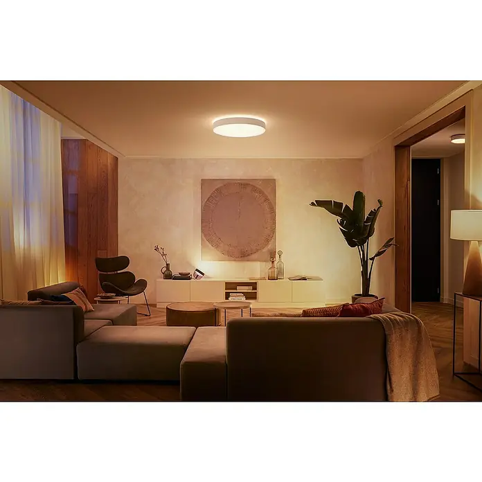 Philips Hue LED-Deckenleuchte rund White Ambience Enrave XL - 48 W, Ø x H: 55,1 x 8,4 cm, Weiß, Kaltweiß - Ein moderner Wohnraum mit einer runden Deckenleuchte, die ein warmes Licht verbreitet und eine angenehme Atmosphäre schafft.