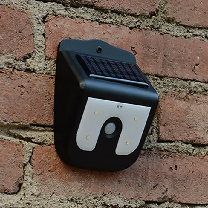 Solar-Außenwandleuchte Vigilamp - 0,8 W, L x B x H: 4,2 x 9,2 x 12,3 cm, Weiß, Schwarz, IP44 - Eine Solarleuchte mit Bewegungsmelder ist an einer Ziegelwand montiert, für den Aussenbereich geeignet.