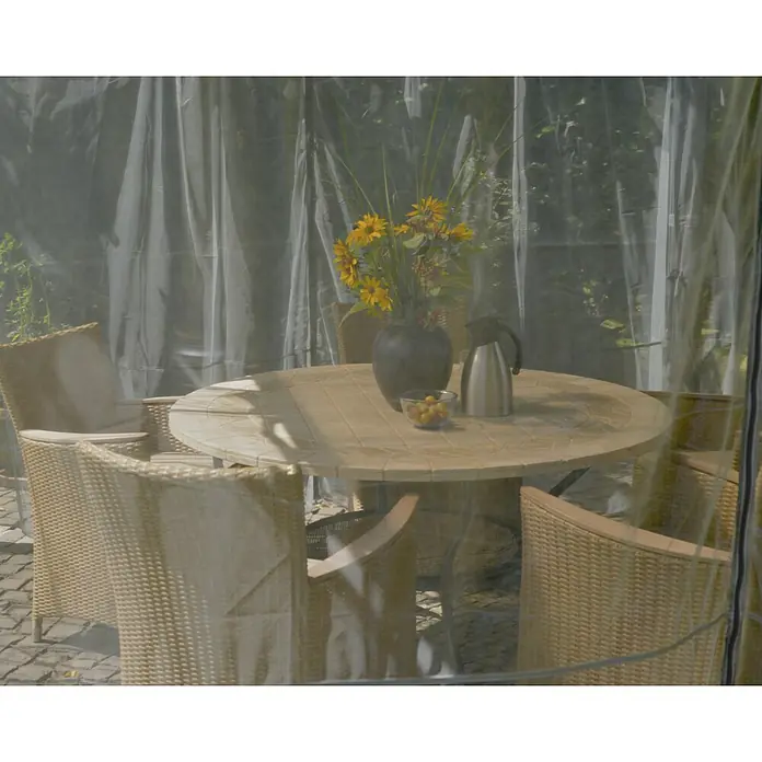Palram – Canopia Cortina mosquitera para cenador Milano - An x Al: 300 x 340 cm - Una mesa de jardín con flores, un termo y un cuenco de fruta, rodeada de sillas en una carpa transparente.