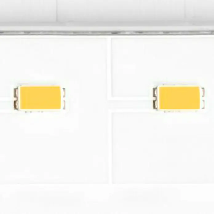 Steinel Foco de pared exterior LED con sensor XLED ONE S - 18,6 W, L x An x Al: 20,2 x 22,9 x 19,5 cm, Blanco, IP44 - Primer plano de dos chips LED amarillos sobre una superficie blanca, integrados en una moderna luminaria.
