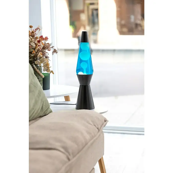 Lámpara de sobremesa decorativa de lava Bullet - 25 W, L x An x Al: 11,5 x 11,5 x 40 cm, Negro - Primer plano de una lámpara de lava azul con base negra sobre una mesa auxiliar, que añade un ambiente retro-moderno a la estancia.