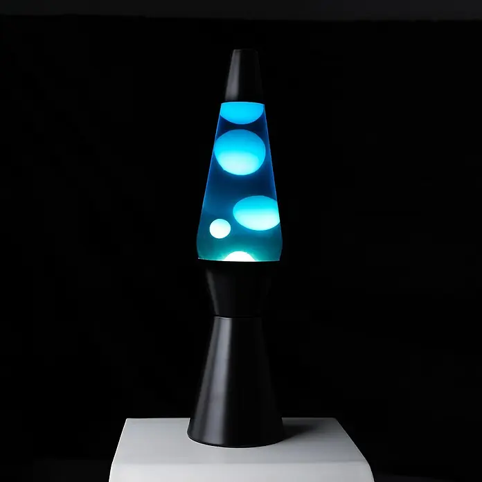 Lámpara de sobremesa decorativa de lava Bullet - 25 W, L x An x Al: 11,5 x 11,5 x 40 cm, Negro - Lámpara de lava azul con base negra sobre superficie blanca, proyectando una luz ambiental relajante.