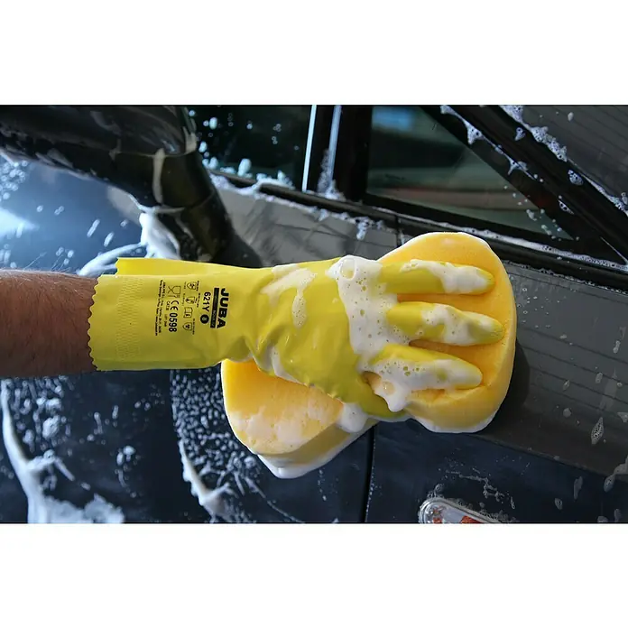 Juba Guantes de trabajo 621Y - Talla del guante: 10, Amarillo, 2 ud. - Primer plano de un guante amarillo Juba sujetando una esponja mientras lava un coche, destacando el proceso de limpieza y los guantes protectores.