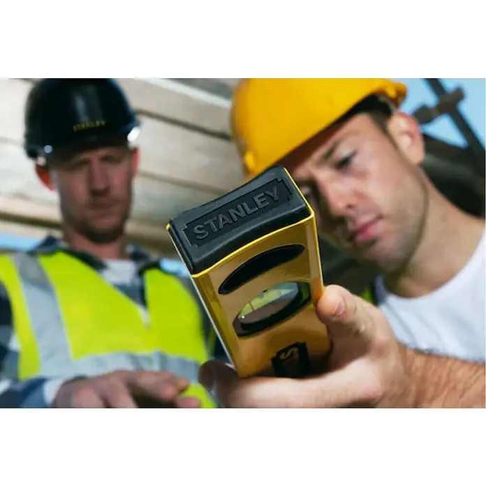 Stanley Nivel de burbuja STHT1-43105 - Aluminio, Amarillo, 100 cm - Dos trabajadores de la construcción con un nivel Stanley amarillo. El nivel Stanley amarillo es el foco principal.