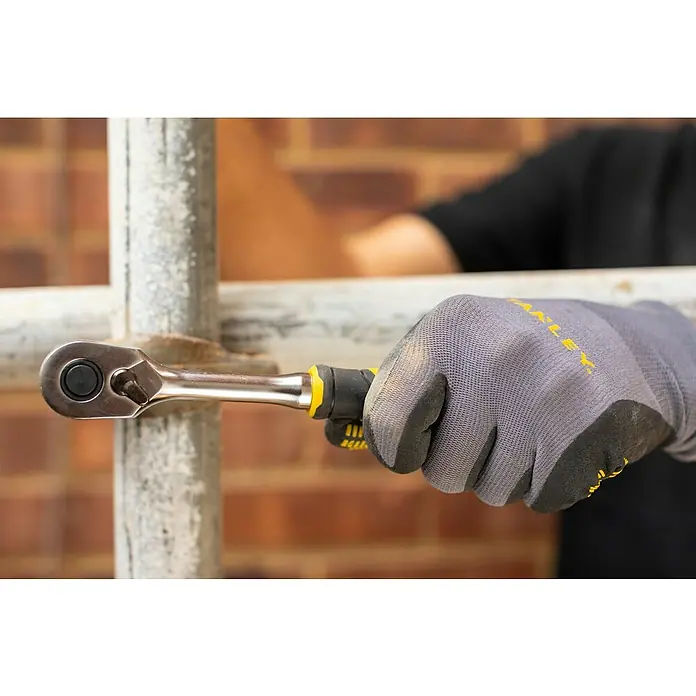 Stanley FatMax Juego de llaves de trinquete FMMT82681-0 - ½″, 22 pzs. - Imagen de una mano con una llave de trinquete Stanley trabajando en un andamio.