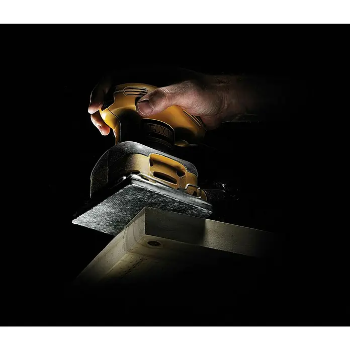 DeWalt Disco de lijado DTM3022-QZ - Grano: 80 mm - Primer plano de una lijadora DeWalt en acción, alisando una pieza de madera, destacando su diseño y funcionalidad.