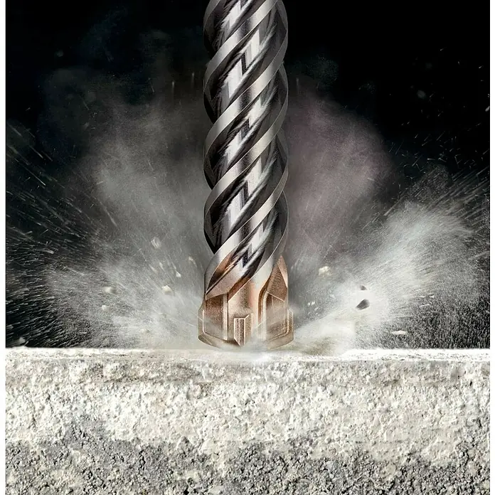 DeWalt Broca para hormigón y mampostería DT60820-QZ - 1 ud., Diámetro de la broca: 22 mm, 400 mm - Primer plano de una broca helicoidal que penetra en una superficie de hormigón, creando polvo y pequeñas partículas.
