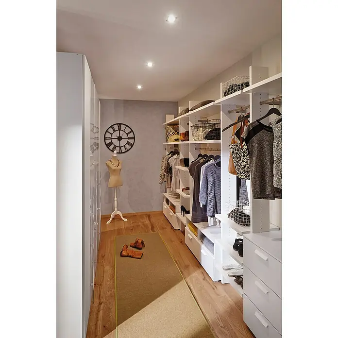 Paulmann Nova LED-Einbauleuchten-Set Coin - L x B x H: 8,4 x 8,4 x 4,5 cm, Weiß matt, 3 Stk., Warmweiß, Dimmbar - Begehbarer Kleiderschrank mit weißem Schranksystem, Kleidung, Schuhen und Dekorationen. Eine Schneiderpuppe und eine Uhr schmücken den Raum.