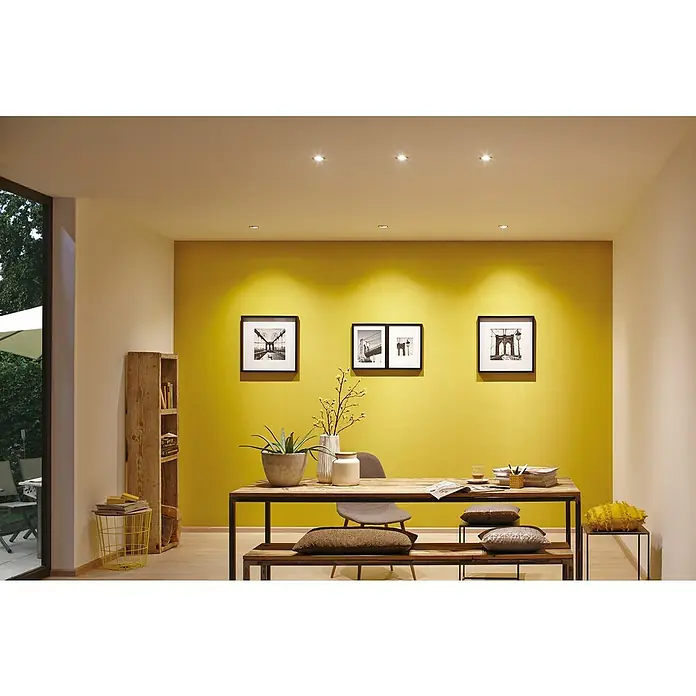 Paulmann Nova LED-Einbauleuchten-Set Plus Coin - L x B x H: 8,4 x 8,4 x 4,5 cm, 3 Stk., Lichtfarbe: Warmweiß, Weiß matt - Innenaufnahme eines stilvollen Esszimmers mit Holztisch, modernen Stühlen und dekorativen Elementen unter warmem Deckenlicht.