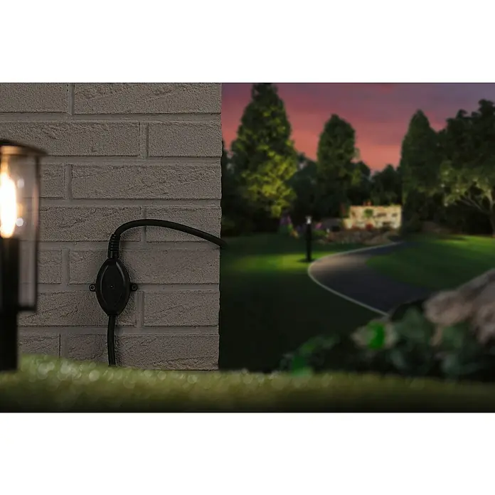 Paulmann Plug & Shine Dämmerungssensor Twilight - Kabellänge: 0,46 cm - Nahaufnahme eines Außenbereichs mit einer Wandleuchte und einem Stromkabel an einer Ziegelmauer.