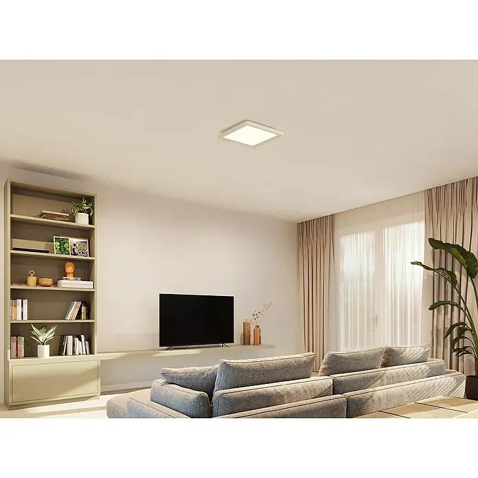 Philips Hue LED-Panel White Ambiance Tento S - 10,6 W, L x B x H: 29,5 x 29,5 x 3,5 cm, Weiß, Kaltweiß - Deckenleuchte: Eine moderne quadratische Deckenleuchte erhellt ein stilvolles Wohnzimmer mit Bücherregal, TV und grauer Couch.