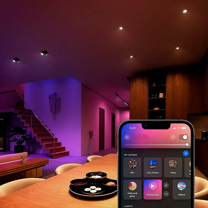 Philips Hue Smart-LED-Lampe White & Color Ambiance - GU10, Dimmbar, RGBW, 400 lm, 4,2 W, 3 Stk. - Smartphone mit einer App zur Steuerung von smarten Philips Hue Lampen in einem modern beleuchteten Wohnraum.