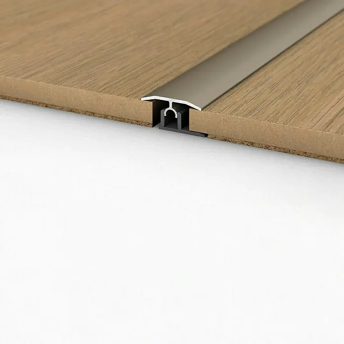 LOGOCLIC Übergangsprofil 303 - Edelstahl matt, 2,7 m x 34 mm, Montageart: Stecken - Das Bild zeigt ein Übergangsprofil zwischen zwei Bodenbelägen, ideal für Laminat oder Parkett, und bietet eine saubere und elegante Lösung.