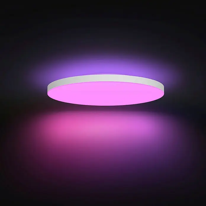 Philips LED-Deckenleuchte rund Datura - 67 W, Ø x H: 60 x 5 cm, Weiß, RGBW - Dieses Bild zeigt eine moderne LED-Deckenleuchte mit einem weißen Rand und einer leuchtend rosa Flächenbeleuchtung in einem dunklen Raum.