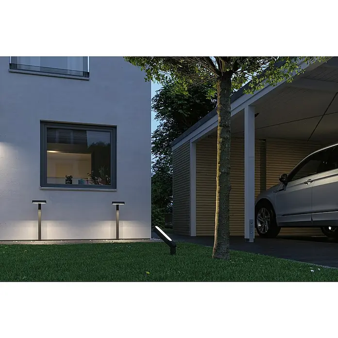 Paulmann Plug & Shine LED-Gartenspot Ito - 7,5 W, Warmweiß, L x B x H: 18,8 x 2,7 x 110 cm - Außenansicht eines modernen Hauses mit Rasenbeleuchtung.
