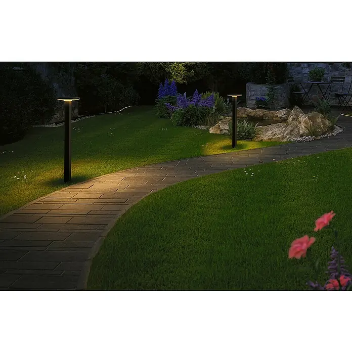 Paulmann Plug & Shine LED-Außenleuchte Plate insektenfreundlich - 7 W, Bernstein, IP44, Farbtemperatur: 2.200 K - Eine Gartenlandschaft mit Wegbeleuchtung. Die modernen Leuchten säumen einen Steinpfad durch grünes Gras und üppige Vegetation im Garten.