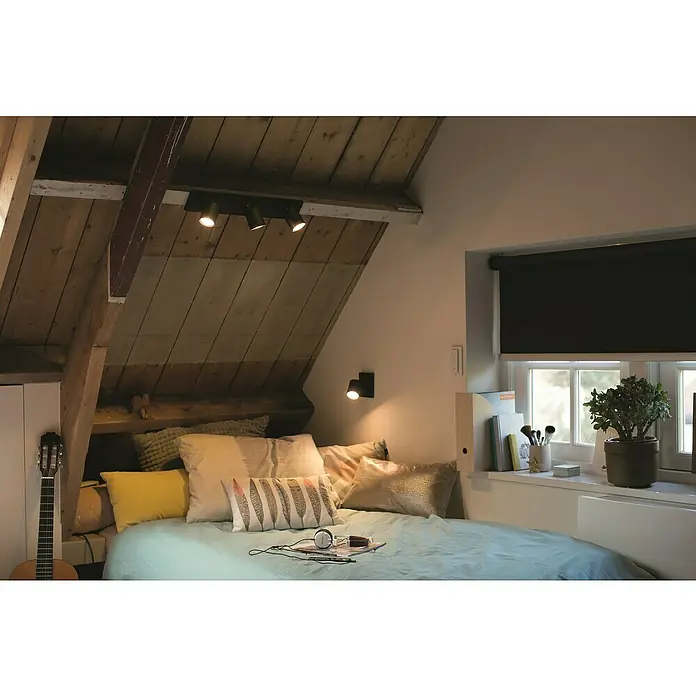 Philips Hue LED-Deckenstrahler White Ambience Runner Erweiterung - 4,2 W, L x B x H: 9 x 11 x 10,7 cm, Schwarz, Mehrfarbig - Ein Schlafzimmer mit einer Deckenleuchte mit drei Strahlern an einer Holzbalkendecke. Ideal für stimmungsvolle Beleuchtung.