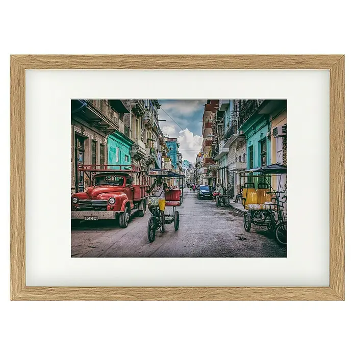 Papermoon Bild - Habana Street, B x H: 100 x 70 cm, Mit Passepartout, Rahmen Eiche - Gerahmtes Bild einer belebten Straße in Havanna, Kuba, mit einem roten Oldtimer-LKW und einem Fahrradtaxi im Vordergrund.