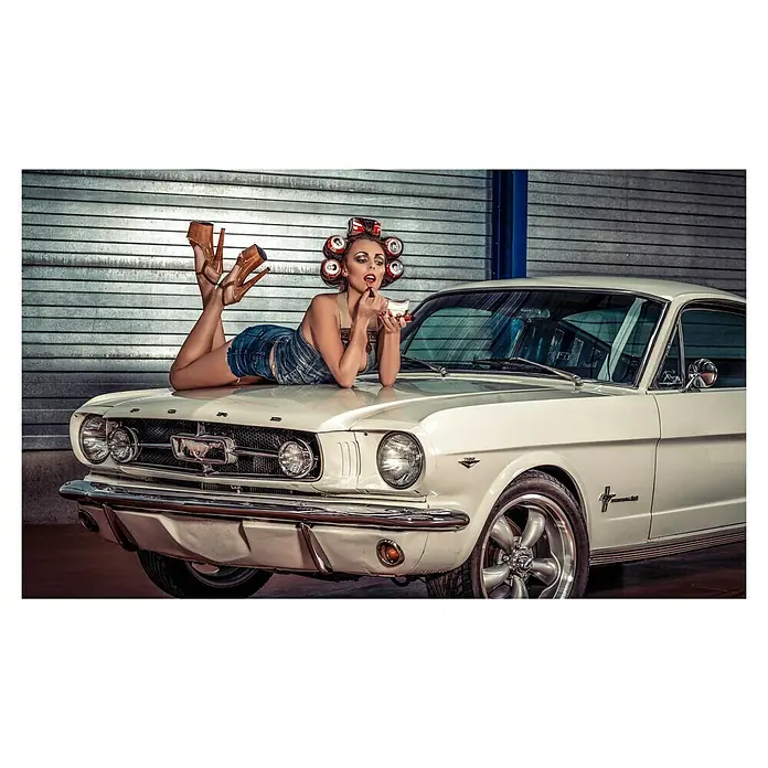 Papermoon Poster - Drive my Car, B x H: 70 x 50 cm, Ohne Passepartout - Ein elegantes weißes Ford Mustang Oldtimer-Auto mit einer Frau, die mit Lockenwicklern auf der Motorhaube liegt.