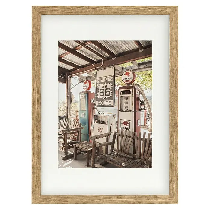 Papermoon Bild - Route 66 Gas Station, B x H: 100 x 140 cm, Mit Passepartout, Rahmen Eiche - Gerahmtes Bild einer historischen Tankstelle an der Route 66 mit alten Zapfsäulen und Sitzgelegenheiten, ideal für Retro-Dekorationen.