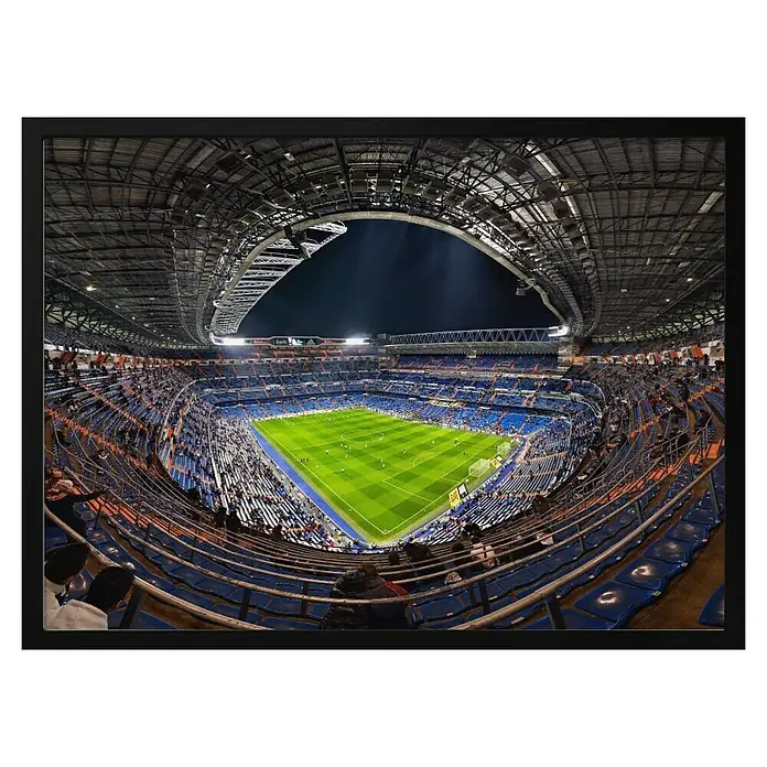 Papermoon Bild - Santiago Bernabèu, B x H: 110 x 80 cm, Ohne Passepartout, Rahmen Schwarz - Innenansicht des Fussballstadions Santiago Bernabéu in Madrid, blaue Sitze, grüner Rasen und Dachkonstruktion mit Öffnung zum Nachthimmel.